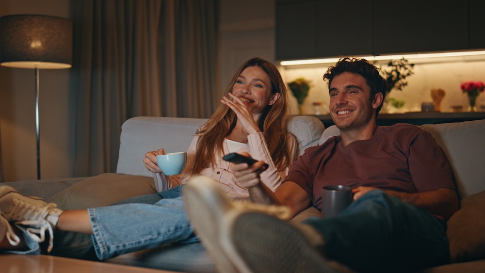 Man and woman on couch watching tv
