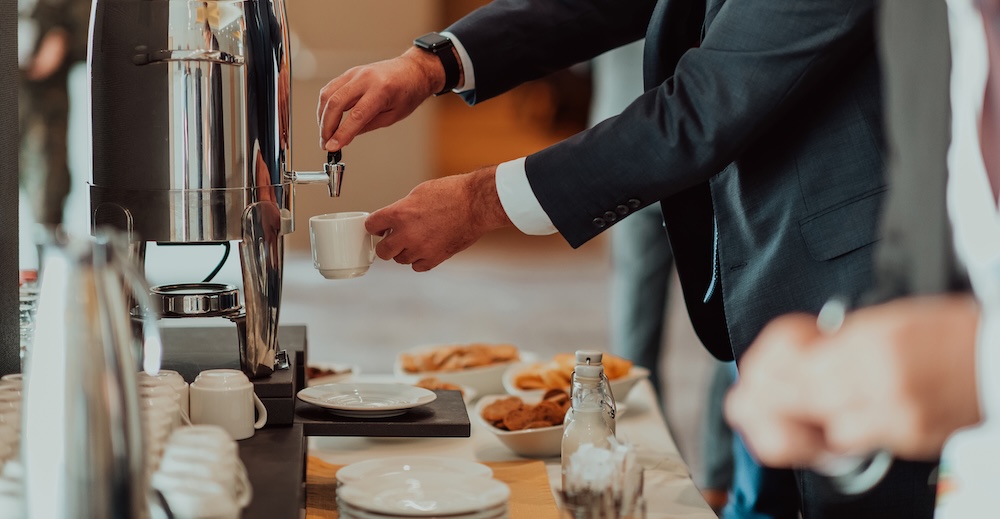 Close-up photo of businessmen serving themselves in a modern hotel