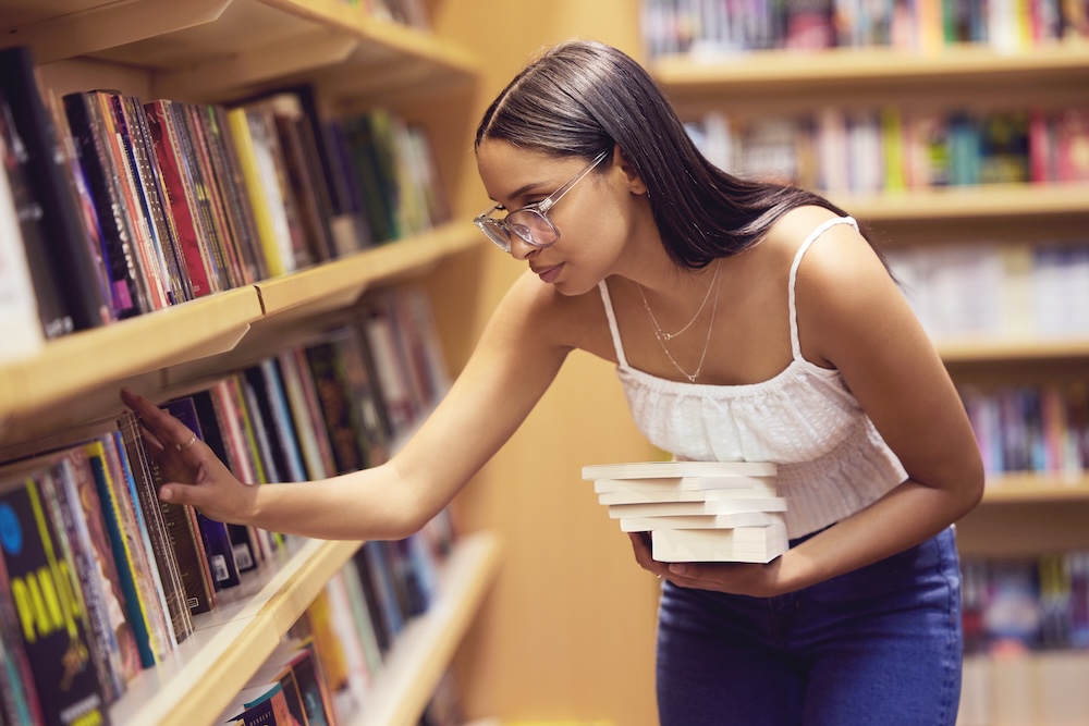 Library, books and woman reading print book