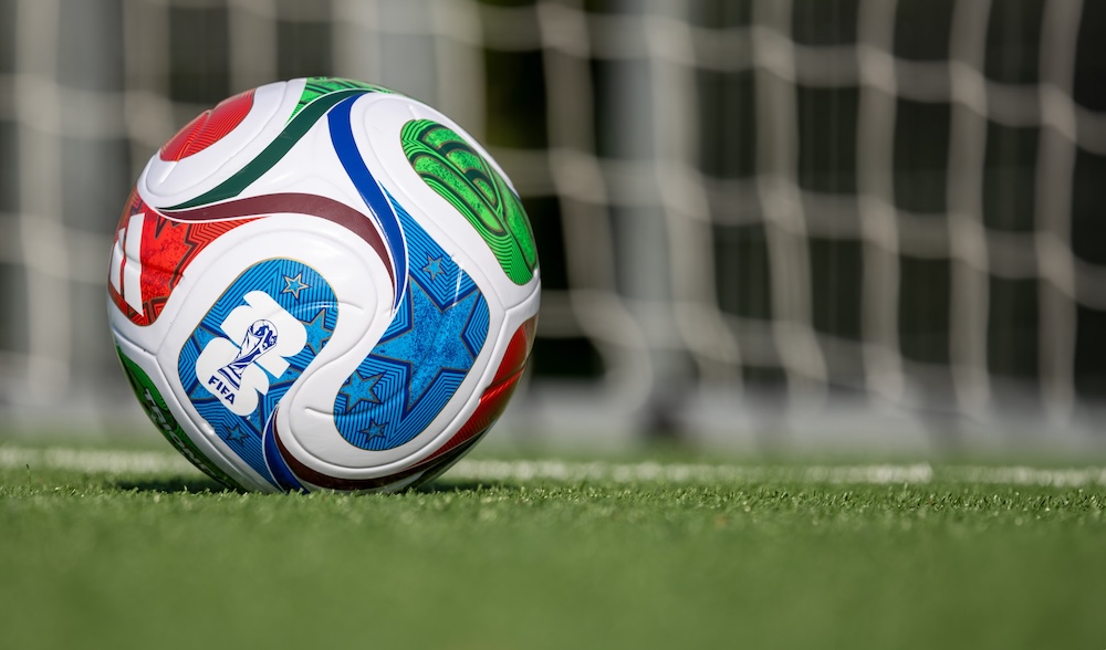 FIFA World Cup 2026 ball on field in front of blurred goal.