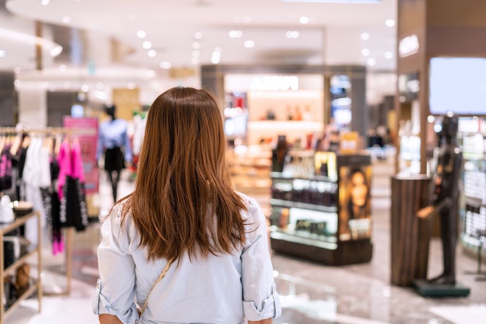Young woman walking in clothes store at the mall
