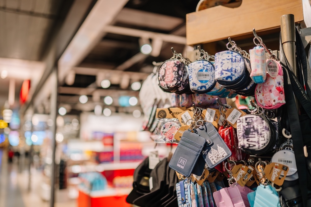 A display of colorful keychains, coin purses, and souvenirs in an airport gift shop