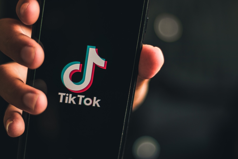 hand holding smartphone with screen tiktok logo
